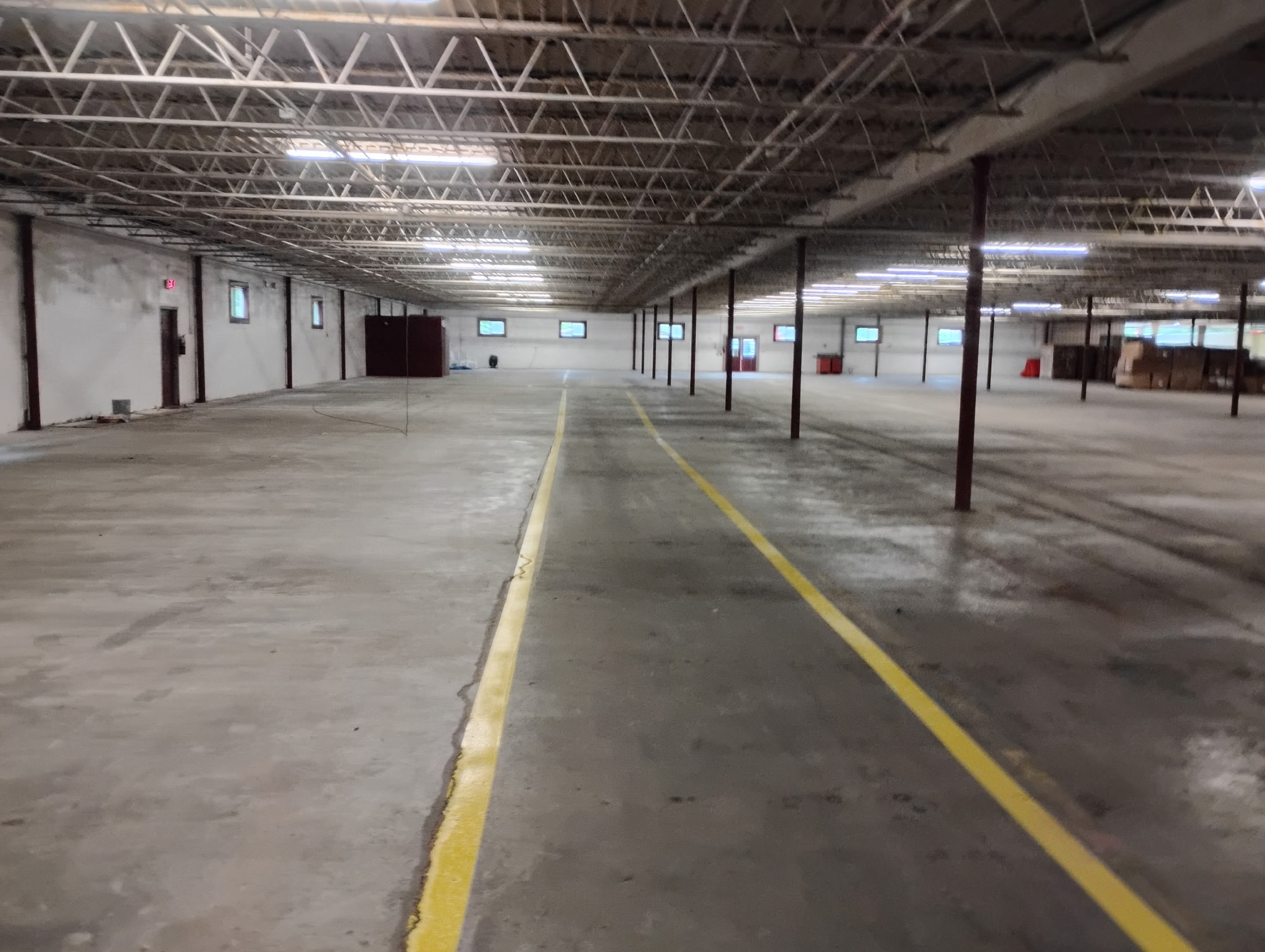 Warehouse interior along a marked aisle showing scale, lighting, and column spacing